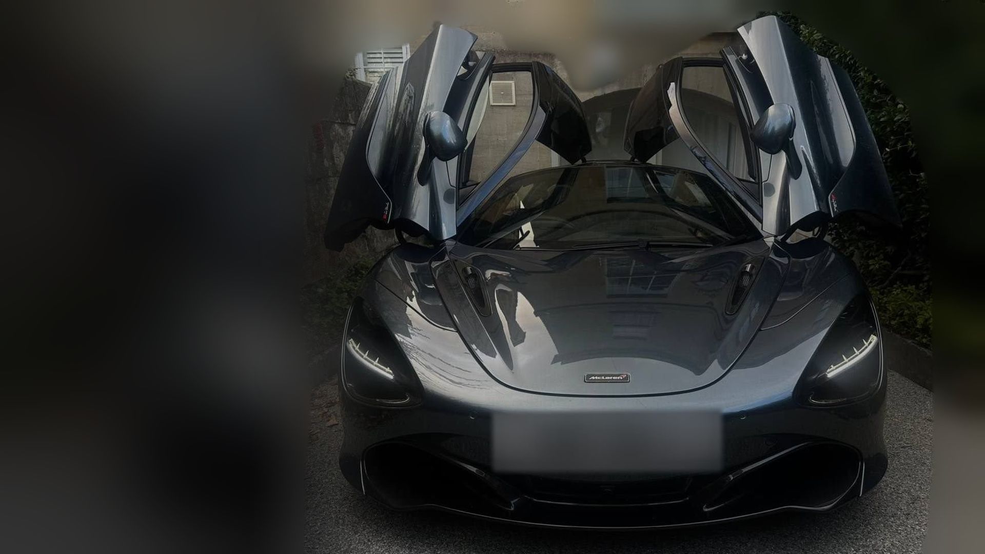 A freshly detailed McLaren 720S with its doors up on a driveway