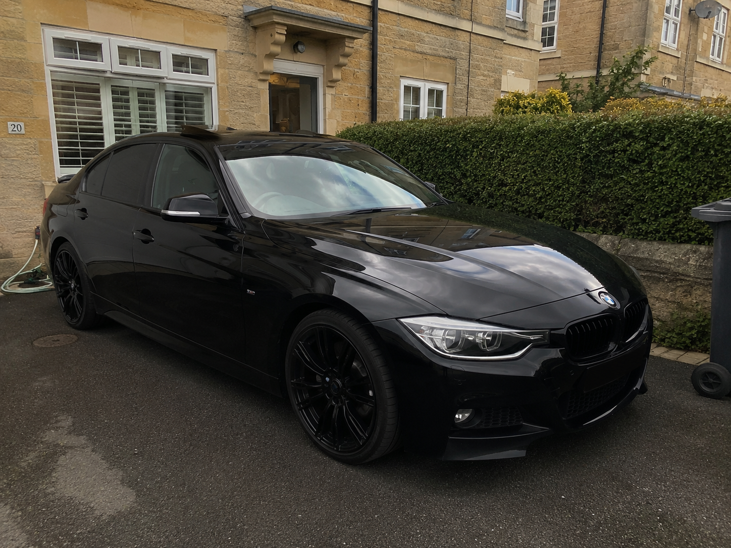 A detailed black BMW parked on a driveway in Bath